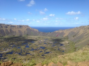 The crater of Rano Kau, which is filled with rain water and contains a micro climate of plants, flowers and animals. Part of the rim has worn away to give a view of the Pacific Ocean 