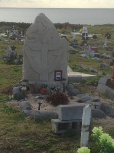 Gravestone with an anchor that is also a crucifix, and the Birdman
