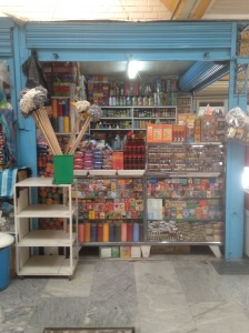 An esoteric stall in the market, selling soaps, candles, powders, potions, incense and mops. 