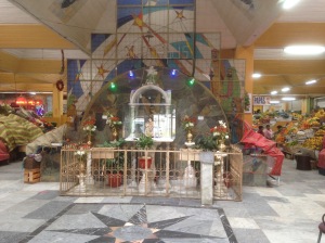 The first thing you see on entering the market is a shrine to Mary with coloured lights amongst the fruit stalls